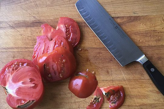 Wusthof santoku knife with tomato slices