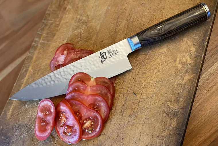 Shun Premier chef knife slicing tomatoes